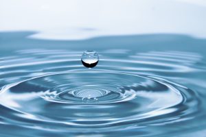 Beautiful background of water drop falling on water